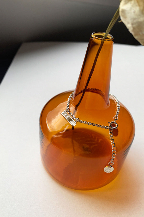 Tinicoterie Let It Roll Pearl Bracelet in Sterling Silver - styled on a burnt orange vase