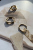 Tinicoterie Stream of Consciousness Ring Set (Aella, Bria, Ember Ring) in gold vermeil styled on textured paper